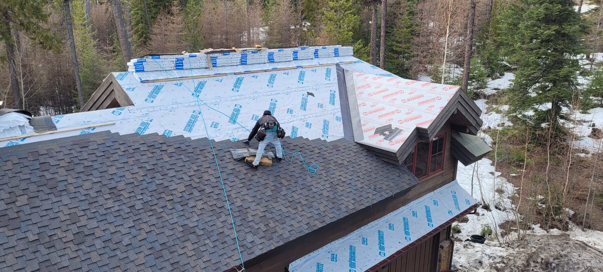 A Roofer installing new roof on a kalispell home