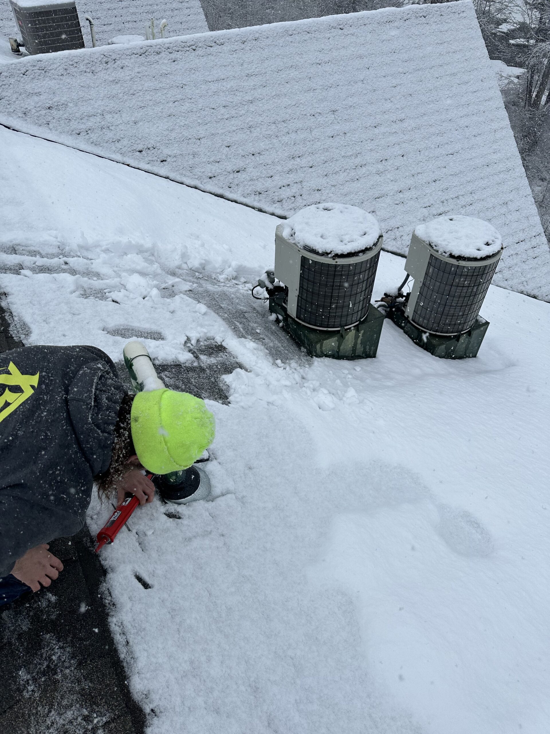 Brix Systems Roofing Contractor inspecting a roof in the winter with snow on top